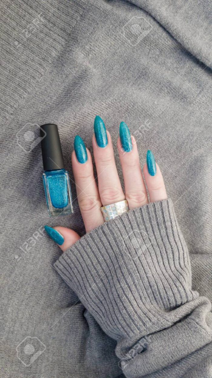 Female Hand With Long Nails And Turquoise Blue Manicure With